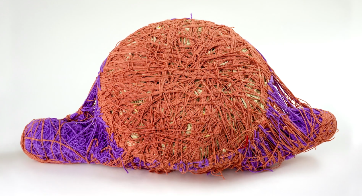 large circular ball covered in orange yarn with two wings covered in purple yarn