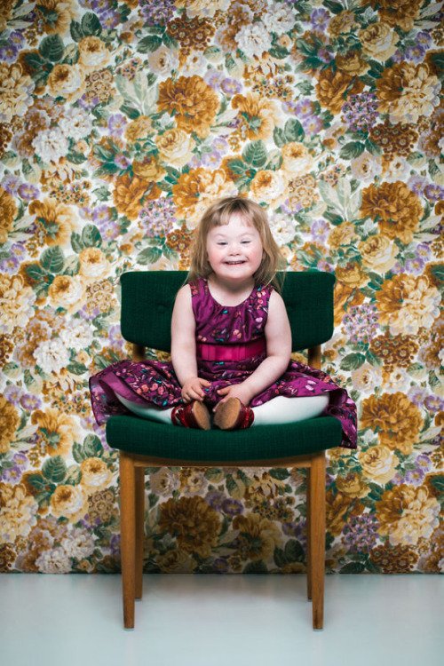 picture of your girl with Down syndrome wearing purple dress sitting in a chair
